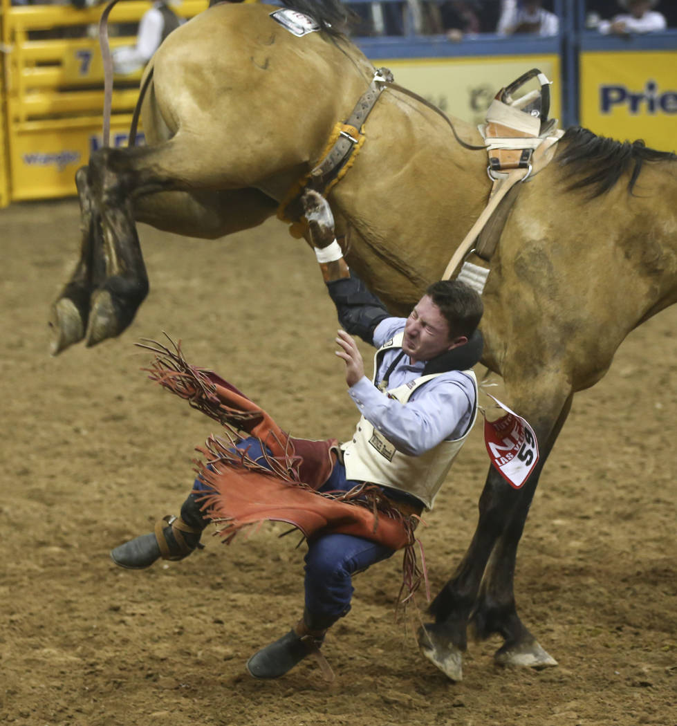 Bill Tutor is bucked off while competing in the bareback riding event during the second night of the National Finals Rodeo at the Thomas & Mack Center in Las Vegas on Friday, Dec. 8, 2017. Cha ...